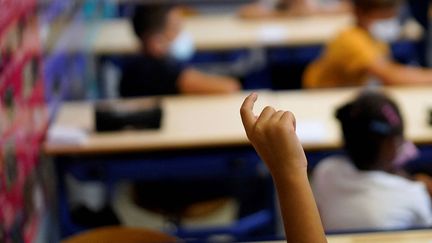 Un enfant lève le doigt&nbsp;dans une école de Marseille, le 2 septembre 2021. (DANIEL COLE / AFP)