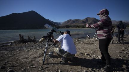 Des Chiliens se préparent à observer l'éclipse de soleil, le 2 juillet 2019 à Puclaro (Chili). (CLAUDIO REYES / AFP)