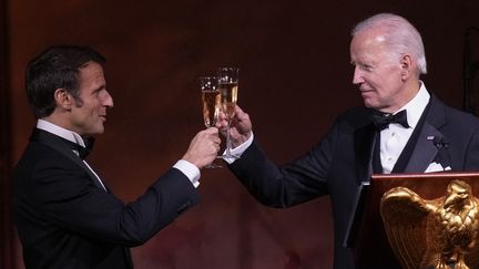 Le président américain Joe Biden et le président français Emmanuel Macron portent un toast après avoir pris la parole lors du dîner d'État sur la pelouse sud de la Maison Blanche, le 1er décembre 2022 à Washington, DC. (DREW ANGERER / GETTY IMAGES NORTH AMERICA)