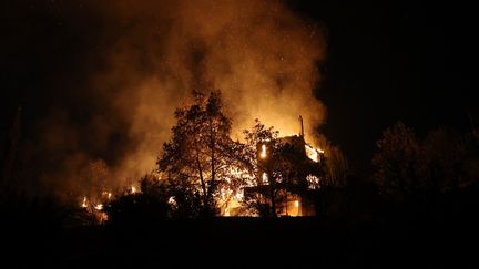 Une maison brûle à Varnava, un village au nord d'Athènes (Grèce), le 11 août 2024. (COSTAS BALTAS / ANADOLU / AFP)