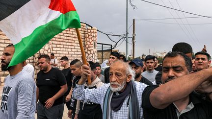 Des personnes en deuil défilent avec le corps d'un adolescent palestinien tué dans un raid militaire israélien, à Jéricho, en Cisjordanie occupée, le 10 avril 2023. (AHMAD GHARABLI / AFP)