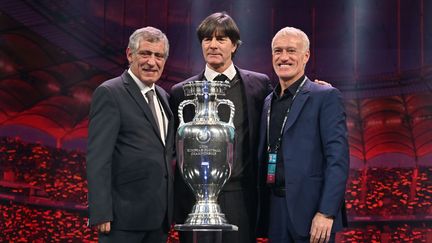 Fernando Santos, l'entraîneur du Portugal, Joachim Loew, le coach allemand et Didier Deschamps, l'entraîneur des Bleus, avec le trophée de l'Euro 2020, le 30 novembre 2019 à Bucarest (Roumanie). (FABRICE COFFRINI / AFP)