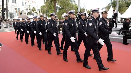 Des policiers en tenue de gala montent les marches, le jour de l'ouverture du Festival de Cannes (Alpes-Maritimes), le 8 mai 2018. (TIMM / FACE TO FACE / SHUTT / SIPA / REX)