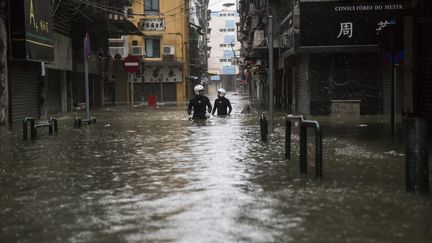 Des secouristes progressent dans les rues inondées de Macao, en Chine, le 16 septembre 2018.&nbsp; (ISAAC LAWRENCE / AFP)