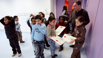 Des &eacute;l&egrave;ves de l'&eacute;cole primaire Olympe de Gouges de Bondy (Seine-Saint-Denis), avec leur professeur de musique, en 2008. (PATRICK KOVARIK / AFP)