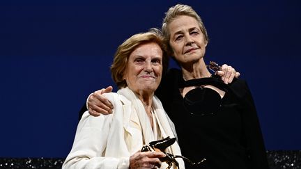 La réalisatrice italienne Liliana Cavani pose avec l'actrice britannique Charlotte Rampling le 30 août après avoir reçu un Lion d'or d'honneur pour l'ensemble de sa carrière lors de la cérémonie d'ouverture de la 80e Mostra de Venise (GABRIEL BOUYS / AFP)