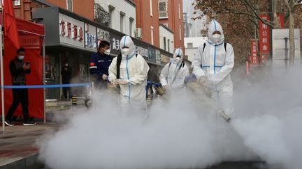 Des hommes désinfectent la ville de&nbsp;Zhengzhou (Chine), le 11 janvier 2021. (MAXPPP)