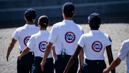 Des jeunes portant des t-shirts du SNU, le 14 juillet 2023, lors du défilé militaire à Paris. (XOSE BOUZAS / HANS LUCAS / AFP)