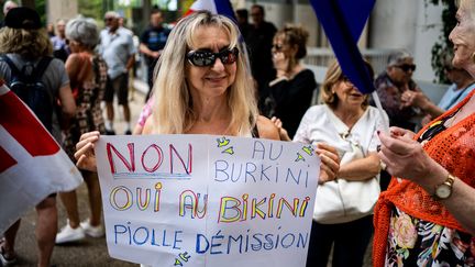 Une femme manifeste contre l'autorisation du port du burkini dans les piscines municipales, avant la réunion du conseil municipal, le 16 mai 2022 à Grenoble (Isère). (NICOLAS LIPONNE / HANS LUCAS / AFP)