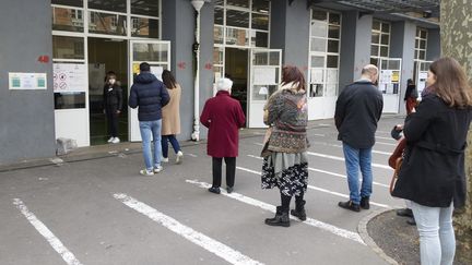 Dans ce bureau de vote à Paris, on&nbsp;respecte les consignes des autorités sanitaires : une distance d'un mètre minimum doit être observée entre chaque personne.&nbsp; (ADNAN FARZAT / NURPHOTO / AFP)