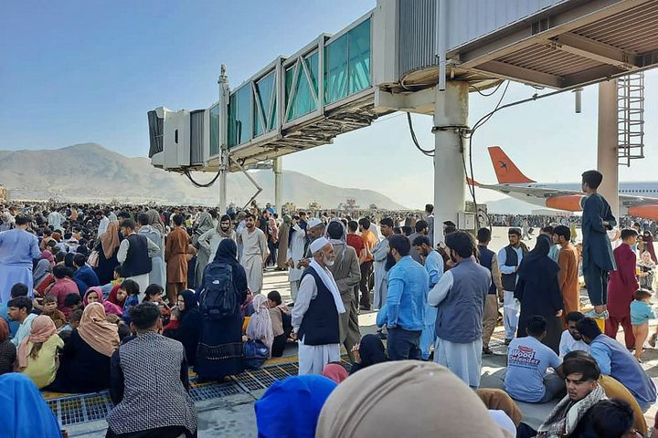 Des&nbsp;centaines d'Afghans se pressent sur le tarmac de l'aéroport de Kaboul, le 16 août 2021, dans l'espoir de fuir le pays. (AFP)