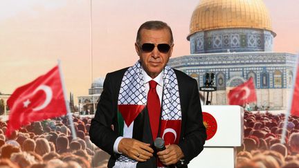 Le président turc Tayyip Erdogan, portant un foulard avec les drapeaux palestinien et turc, lors d'un rassemblement en solidarité avec les Palestiniens de Gaza, à Istanbul, le 28 octobre 2023. (HANDOUT / TURKISH PRESIDENCY PRESS OFFICE / AFP)