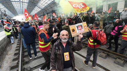 Des syndicalistes du secteur ferroviaire et des manifestants se tiennent sur les voies à la gare de Bordeaux (Gironde), le 17 mars 2023, pour protester contre la réforme des retraites. (MEHDI FEDOUACH / AFP)