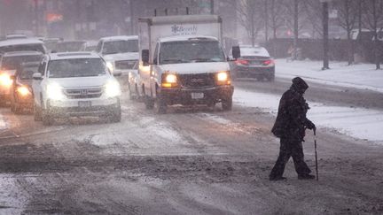 Un piéton traverse une route enneigée à Chicago, dans l'Illinois (Etats-Unis), le 22 décembre 2022. (SCOTT OLSON / GETTY IMAGES NORTH AMERICA / AFP)