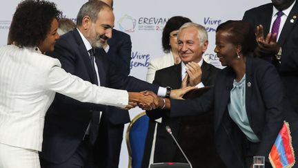 Passation de pouvoir à la tête de l'Organisation internationale de la francophonie entre la canadienne Michaelle Jean (G) et la rwandaise Louise Mushikiwabo (D). Photo prise le 12 octobre 2018 à Erevan (Arménie) en présence du premier ministre arménien Nikol Pashinyan. (LUDOVIC MARIN / AFP)