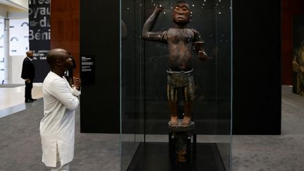 Un visiteur à l'exposition "Art du Bénin d'hier et d'aujourd'hui : de la Restitution à la Révélation", au Marina Palace de Cotonou, Bénin, en 2022. (LUDOVIC MARIN / AFP)