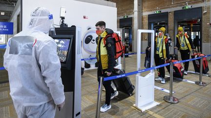 Des membres de la délégation allemande confrontées aux mesures de sécurité et de protection contre le Covid-19 à leur arrivée au village olympique de Pékin le 1er février 2022. (ANTHONY WALLACE / AFP)