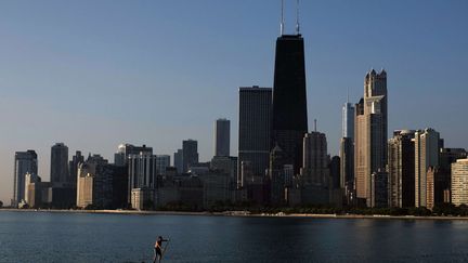 Un homme traverse le lac Michigan sur un stand-up paddle &agrave; Chicago (Illinois, Etats-Unis), le 20 ao&ucirc;t 2014. (KIICHIRO SATO / AP / SIPA)