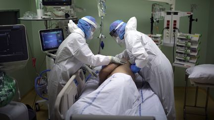 Des soignants s'occupent d'un malade du Covid-19 en réanimation à l'hôpital d'Arles (Bouches-du-Rhône), le 28 octobre 2020. (DANIEL COLE / AP / SIPA)