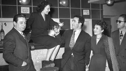 La chanteuse Edith Piaf et le boxeur Marcel Cerdan trinquent au bar du théâtre du "Club des Cinq", à Paris le 17 mars 1948.
 (AFP)