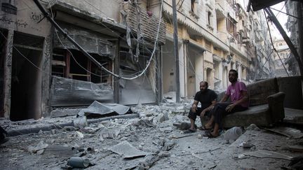 Des habitants d'Alep (Syrie) dans une rue dévastée par un bombardement survenu le 18 septembre 2016, la veille de&nbsp;la fin de la trêve.&nbsp; (KARAM AL-MASRI / AFP)