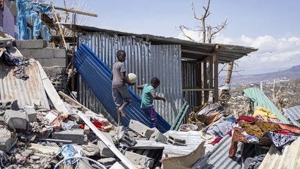 Des enfants jouent avec un ballon de foot dans les décombres à Pamandzi (Mayotte), le 21 décembre 2024.