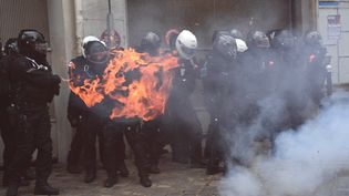 Un engin incendiaire explose devant des policiers lors de la manifestation contre la proposition de loi sur la "sécurité globale", à Paris, le 5 décembre 2020. (ANNE-CHRISTINE POUJOULAT / AFP)