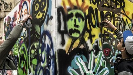 Deux adolescents apprennent à faire des graffitis lors du "Street Day", le 1er avril 2013 à  Lyon.
 (AFP / JEFF PACHOUD)