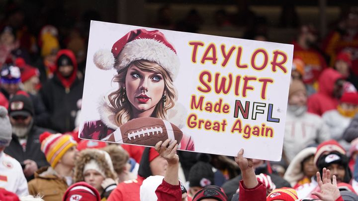 Un supporter des Kansas City Chiefs brandit une pancarte durant le match de NFL contre les Las Vegas Raiders, le 25 décembre 203. La pancarte reprend à son compte le slogan "Make America Great Again" de Donald Trump avec en vedette la superstar de la chanson, Taylor Swift. (ED ZURGA / AP)