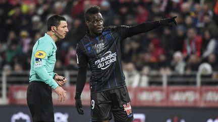 Mario Balotelli montre du doigt une tribune de Dijon à l'arbitre, le 10 février 2018, lors du match Dijon-Nice. (PHILIPPE DESMAZES / AFP)