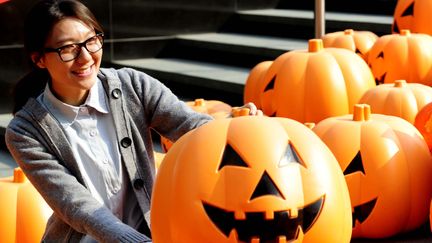 Une Chinoise pose &agrave; c&ocirc;t&eacute; de d&eacute;corations d'Halloween, le 31 octobre 2014 &agrave; Shenyang (Chine). (AFP)