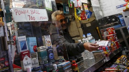 Un homme vend un ticket pour la loterie du Powerball, le 7 janvier 2016, à New York (Etats-Unis).&nbsp; (SHANNON STAPLETON / REUTERS)