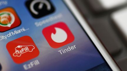 L'application Tinder avec son icone de flamme blanche sur fond rose, le 14 août 2018 (JOE RAEDLE / GETTY IMAGES NORTH AMERICA)