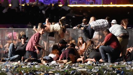 Des spectateurs tentent de se mettre à l'abri, lors d'une fusillade à Las Vegas (Nevada, Etats-Unis), le 1er octobre 2017. (DAVID BECKER / GETTY IMAGES NORTH AMERICA / AFP)