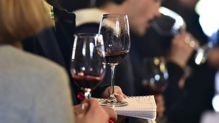 Des personnes goûtent différents vins. (GEORGES GOBET / AFP)