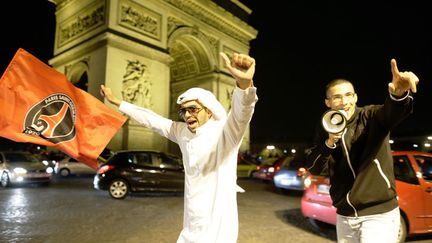 Des supporters du club de football du Paris Saint-Germain (PSG) c&eacute;l&egrave;brent le titre de champion de France de leur &eacute;quipe place de l'Etoile &agrave; Paris, le 12 mai 2013. (KENZO TRIBOUILLARD / AFP)