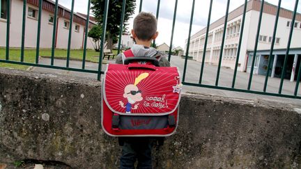 Un enfant devant une cour de récréation. (JULIO PELAEZ / MAXPPP)