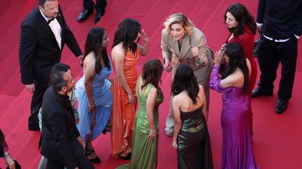 French actress Julie Gayet coaches the six young Egyptians, dressed in colorful dresses, who are presenting a documentary at Critics' Week, "Daughters of the Nile".  The actress, godmother of this project, really fell in love with them.  (PASCAL LE SEGRETAIN / GETTY IMAGES EUROPE)