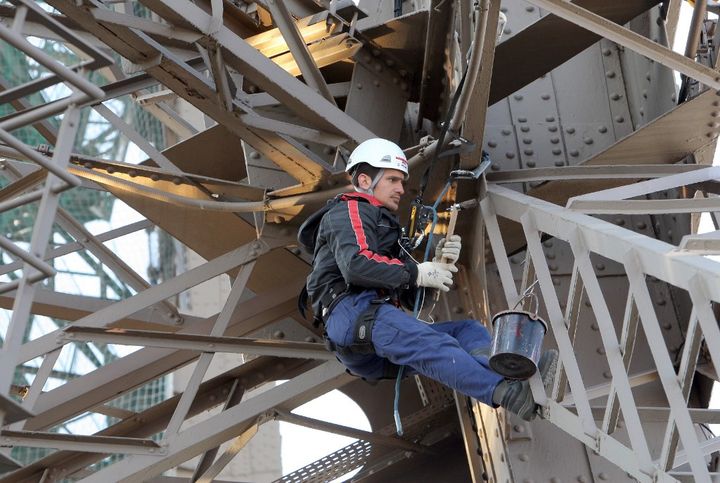 Un peintre au travail sur la Tour Effeil en 2009. (PATRICK KOVARIK / AFP)