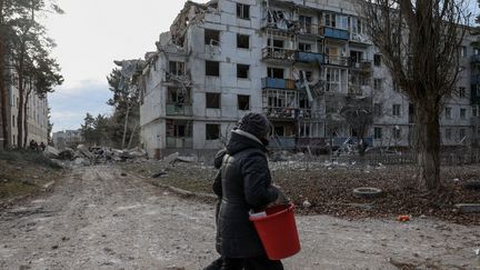 Des habitants dans les rues détruites de Kharkiv (Ukraine), le 2 décembre 2022. (SOFIA BOBOK / ANADOLU AGENCY / AFP)