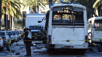 Un enquêteur inspecte le bus visé la veille par une attaque kamikaze à Tunis (Tunisie), le 25 novembre 2015. (FETHI BELAID / AFP)