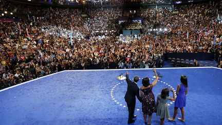 Le pr&eacute;sident am&eacute;ricain Barack Obama (G) salue ses partisans, entour&eacute; de sa femme Michelle et de ses deux filles pendant la convention nationale d&eacute;mocrate &agrave; Charlotte (Caroline du Nord), le 6 septembre 2012. (RICK WILKING / REUTERS)