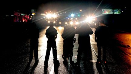 &nbsp; (Des manifestants font face aux force de l'ordre, refusant de libérer la route, dans la nuit de vendredi à samedi. © Robert Cohen/AP/SIPA)