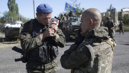 Des soldats ukrainiens s'offrent une pause cigarette, le 5 septembre 2014, lors d'une patrouille pr&egrave;s de Debaltseve (est de l'Ukraine). (ANATOLII STEPANOV / AFP)