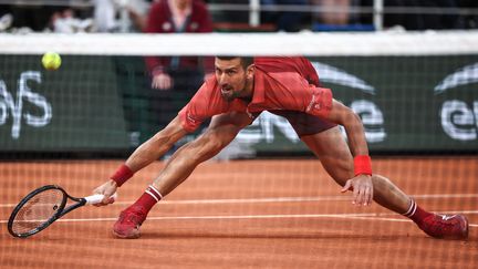 En manque de résultats sur la terre battue en 2024, Novak Djokovic a retrouvé ses talents "d'homme élastique" porte d'Auteuil. (ANNE-CHRISTINE POUJOULAT / AFP)