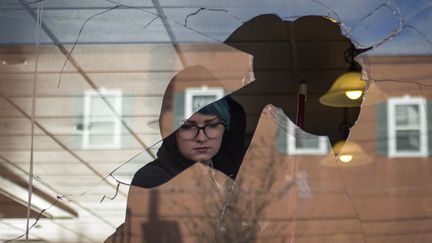 Une jeune femme aide &agrave; nettoyer les d&eacute;bris dans un restaurant endommag&eacute; par des &eacute;meutiers. (ADREES LATIF / REUTERS)