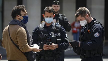 Des policiers effectuent un contrôle d'identité, le 6 juin 2020 à Paris. (GEOFFROY VAN DER HASSELT / AFP)