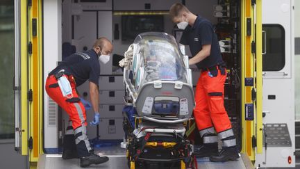 Des ambulanciers allemands chargent dans une ambulance le brancard qui a servi à transférer l'opposant russe Alexeï Navalny à l'hôpital de la Charité à Berlin le 22 août 2020. (ODD ANDERSEN / AFP)