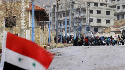 Un drapeau national syrien flotte sur une barricade érigée à l'entrée de la ville syrienne assiégée de Madaya, le 14 janvier 2016. (LOUAI BESHARA / AFP)