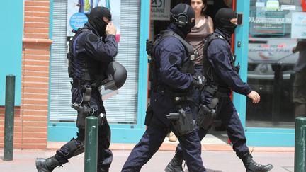 Avenue Pujol, &agrave; Toulouse, des policiers du GIPN arrivent sur les lieux de la prise d'otages qui a d&eacute;but&eacute; dans la matin&eacute;e du 20 juin 2012 dans une agence bancaire. (SEBASTIEN LAPEYRERE / MAXPPP)